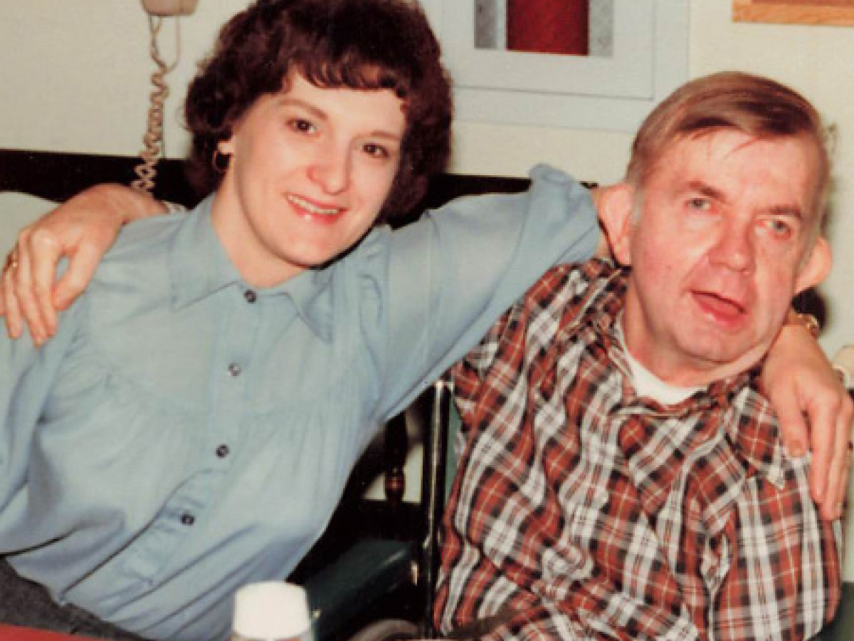 Old photo of support staff and Community Living participant with their arms around each other, smiling at the camera
