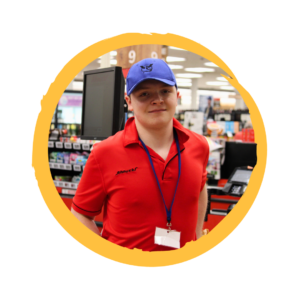 Taylor smiles by the grocery register, waiting to bag groceries for customers.