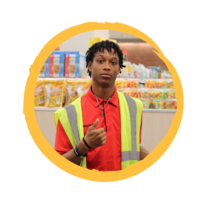 Christian gives a thumbs up standing in front of shopping carts in the grocery store.